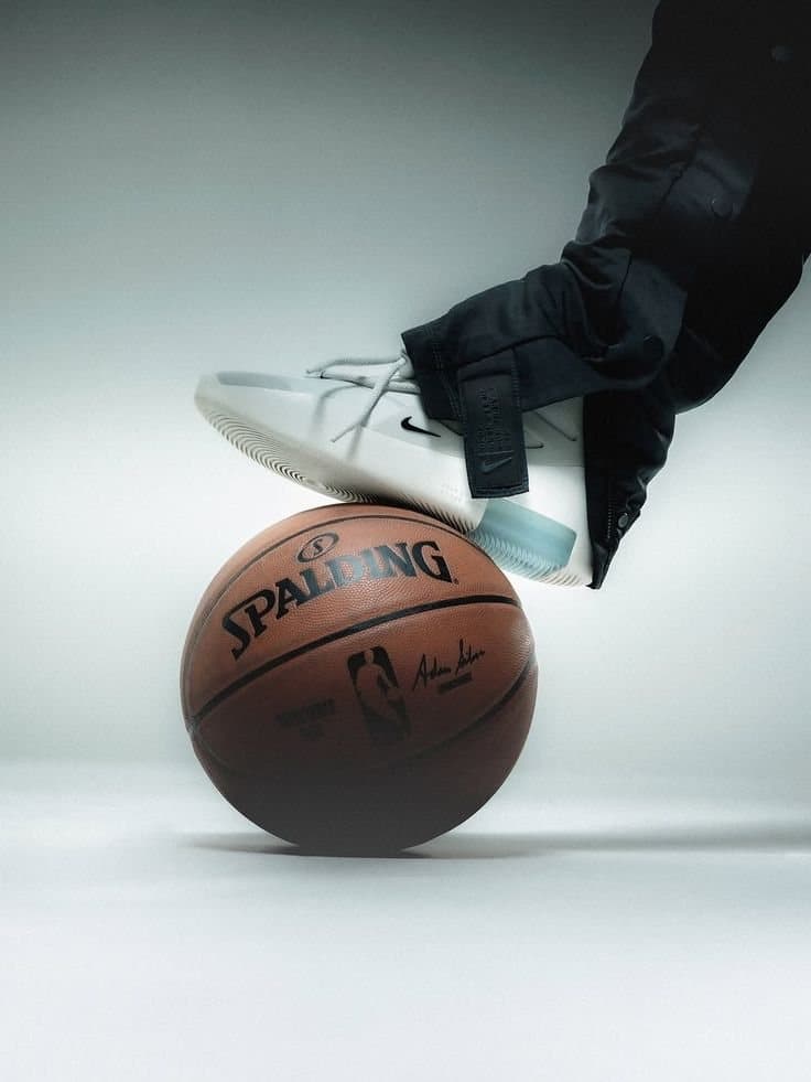 Sneaker claire posée sur un ballon de basket