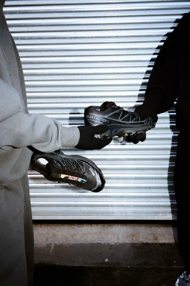 Sneakers trail noires devant un rideau métallique