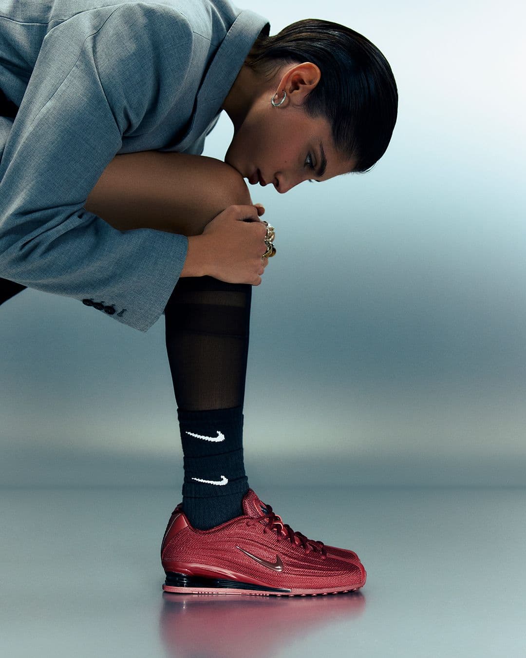 Sneakers bordeaux, chaussettes noires, studio acier